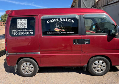 Red van with Paws Salon signage by Arizona Custom Signworks, promoting grooming services. Includes QR code and contact info in Phoenix area.