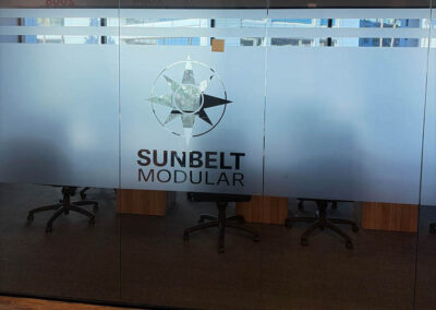 Frosted glass office door with Sunbelt Modular logo, designed by Arizona Custom Signworks, located in a modern Phoenix workspace.